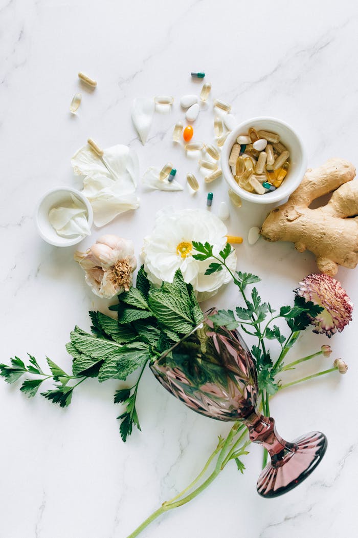 ours-journey Flat lay of herbs, supplements, and ginger on a marble surface, representing natural healthcare.